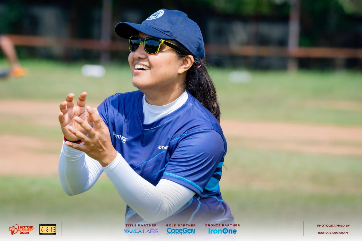 A fielder in blue smiling and clapping