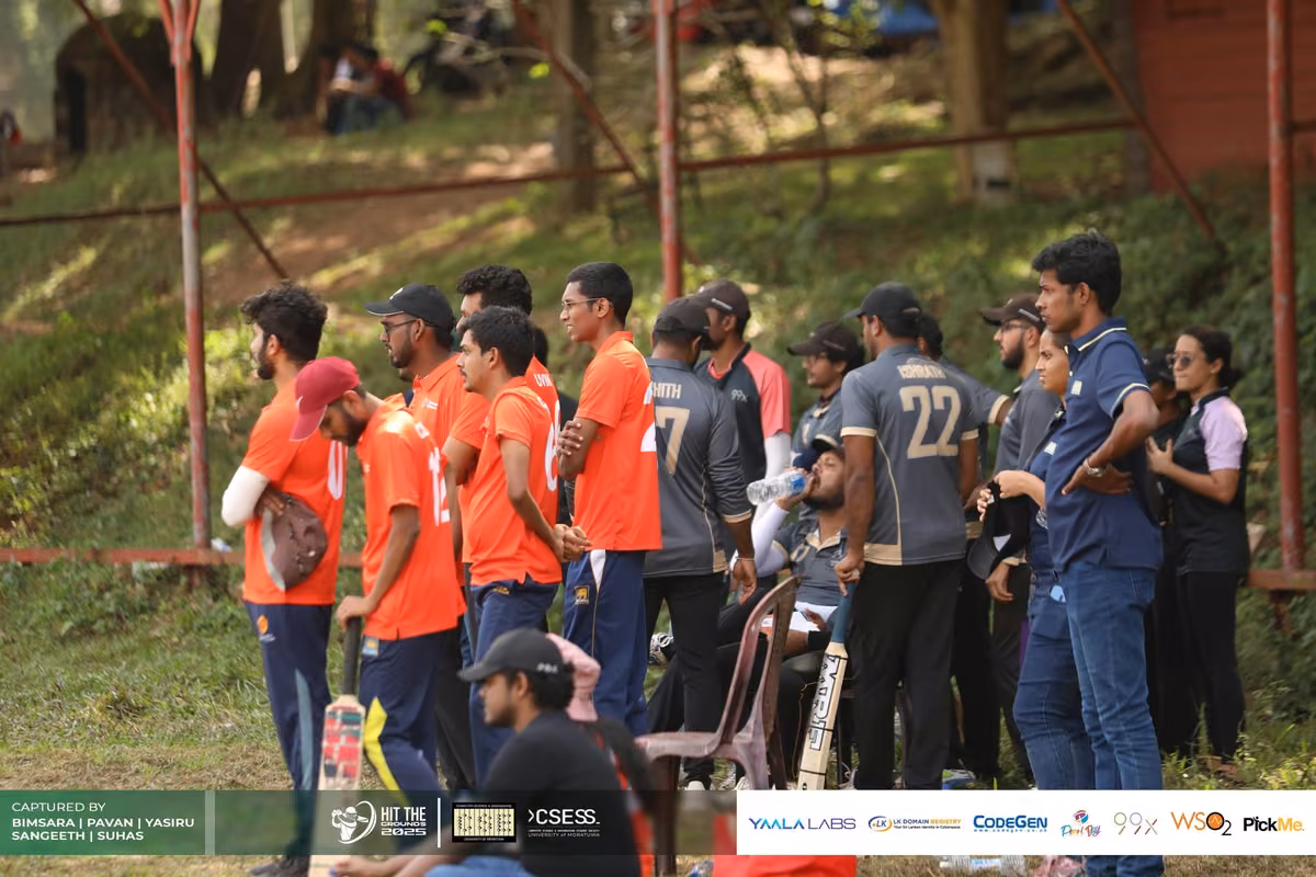 Players in orange watching from the bank