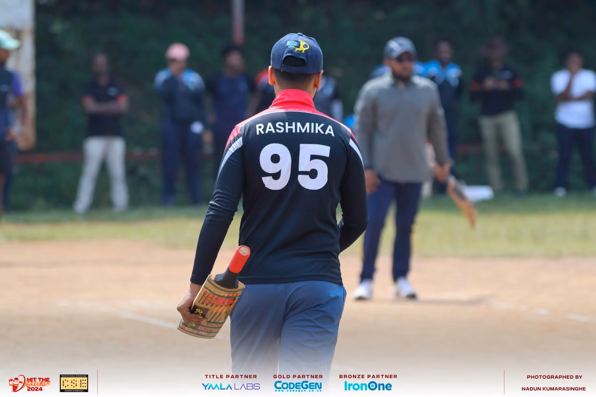 A wicketkeeper in a black jersey numbered 95