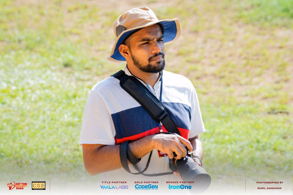 A photographer in a bucket hat with a camera strap