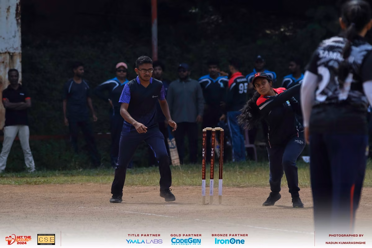 Fielders and a batter at the stumps in low light