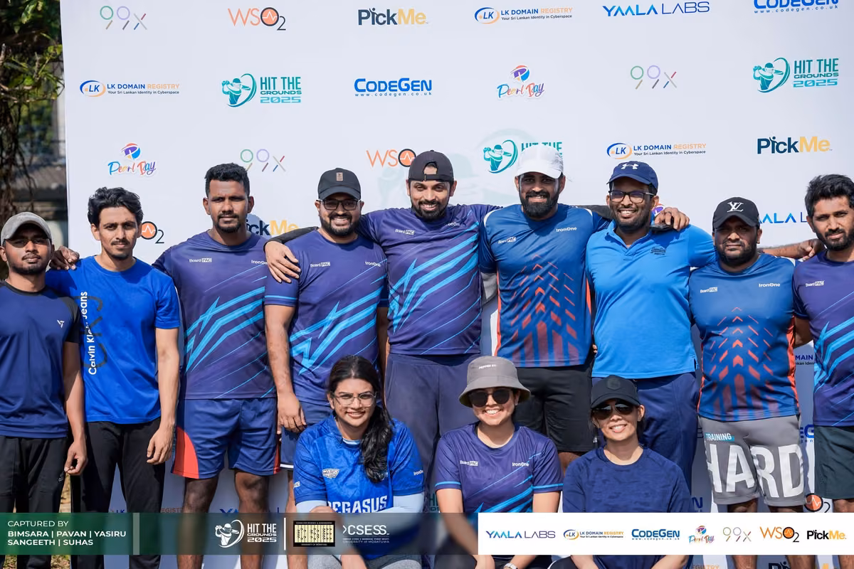 A team in blue and purple jerseys posing in front of the sponsor backdrop