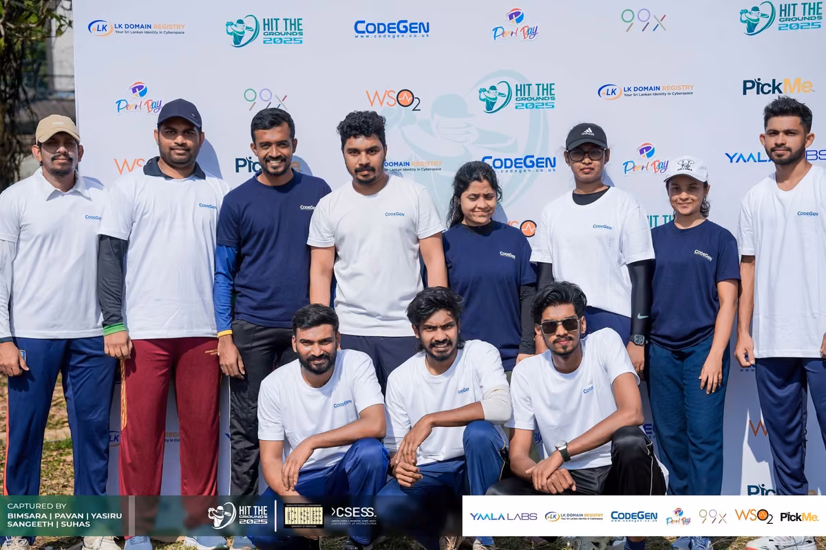 A group in white and navy shirts posing in front of the sponsor backdrop