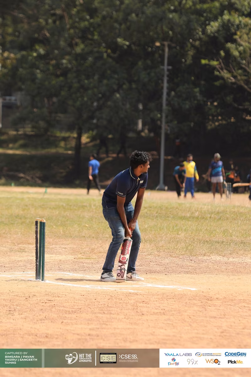 A batter waiting at the stumps on a dry pitch