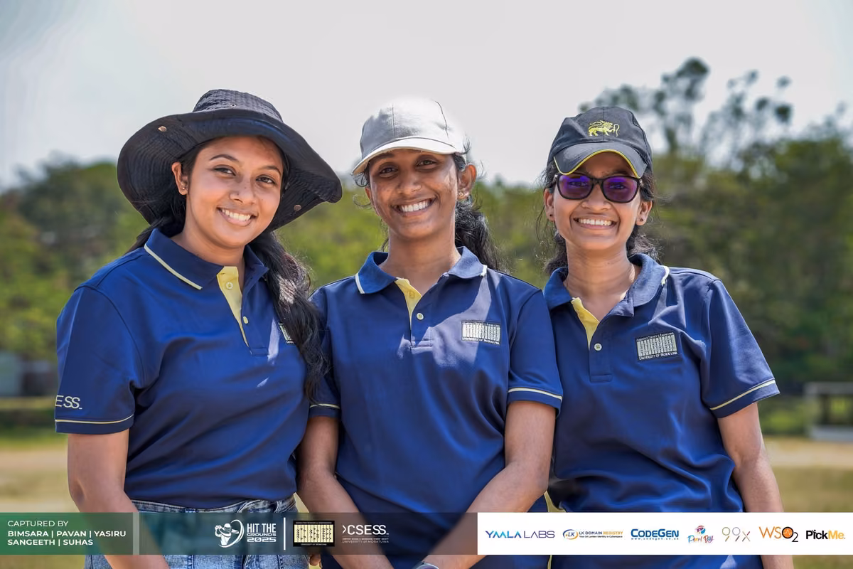 Three women in navy polo shirts and sun hats smiling