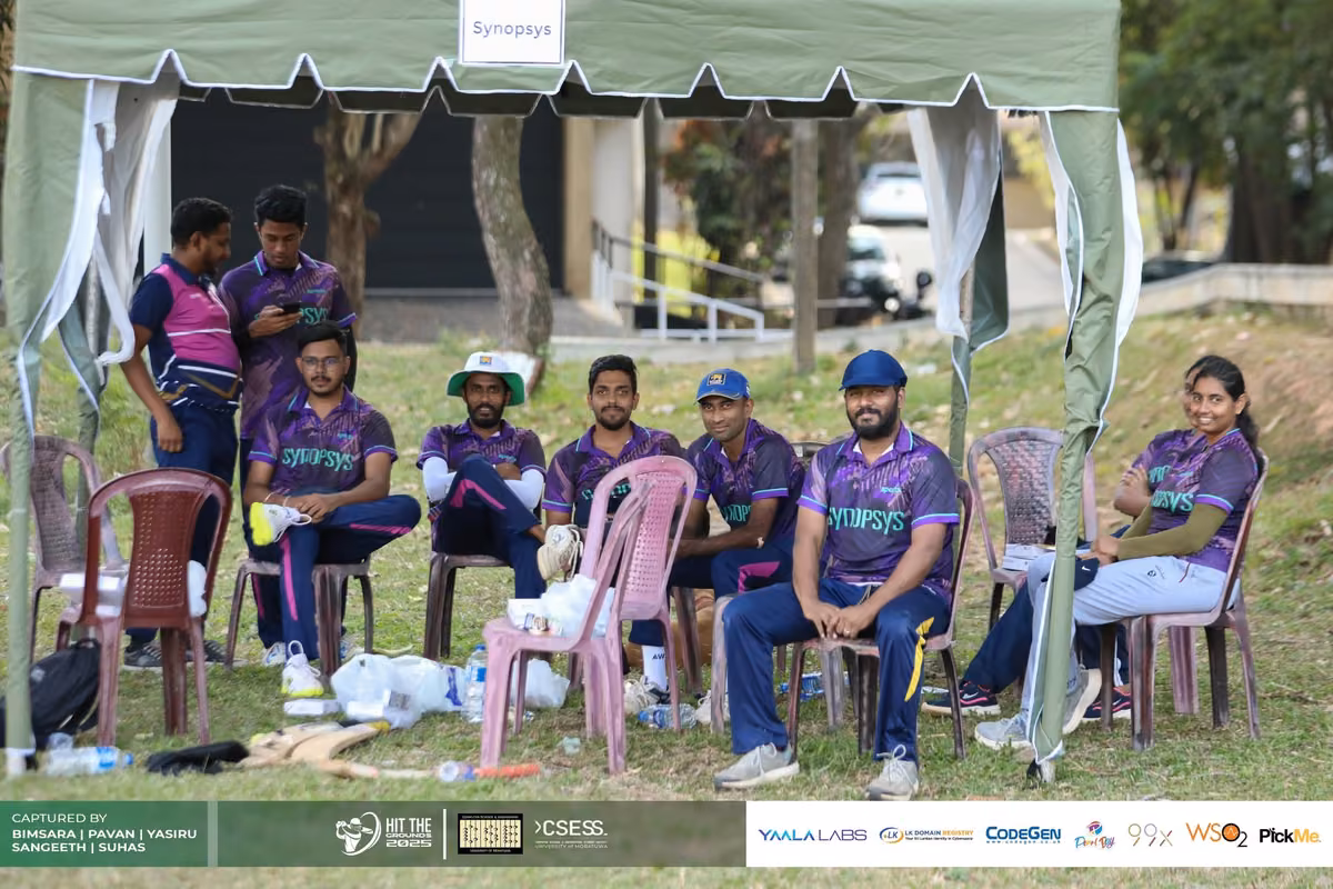 A team in purple jerseys seated under a tent