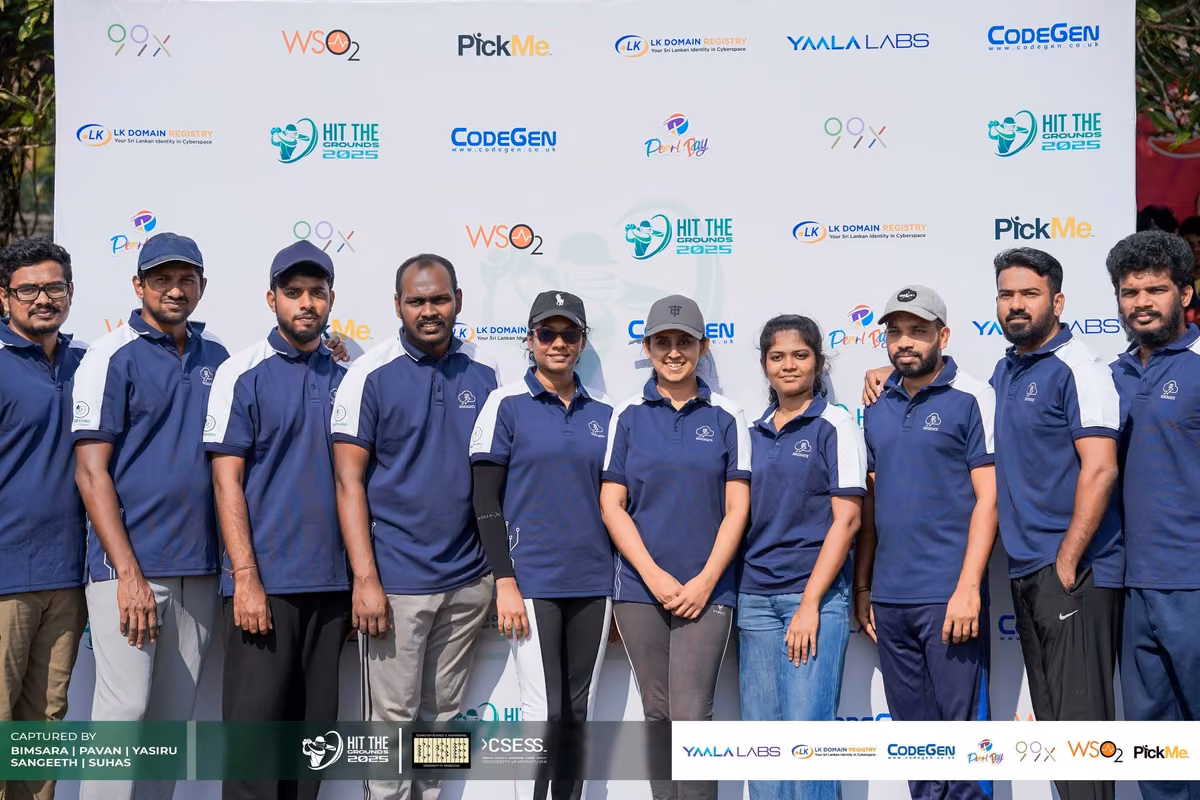 Volunteers in navy polos lined up in front of the sponsor backdrop