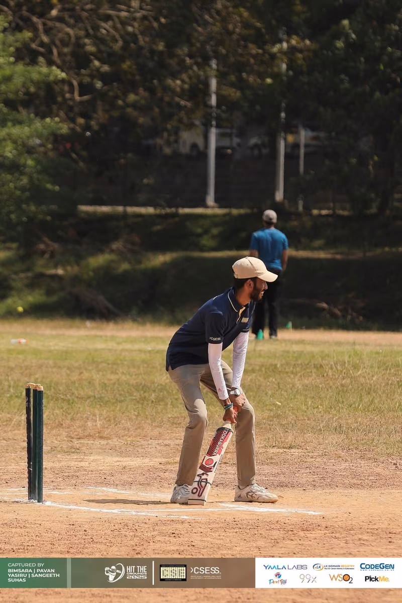A batter taking guard beside the stumps