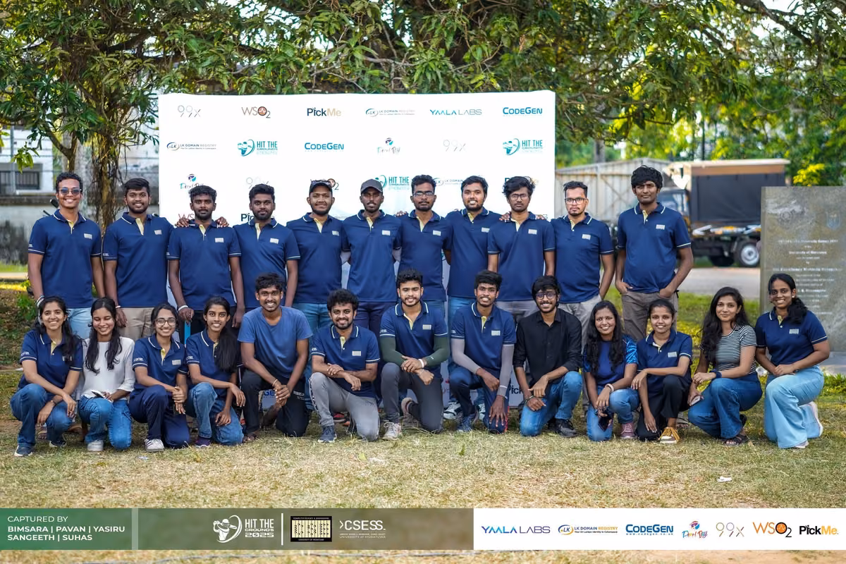 A large group in navy and blue shirts posing on the field
