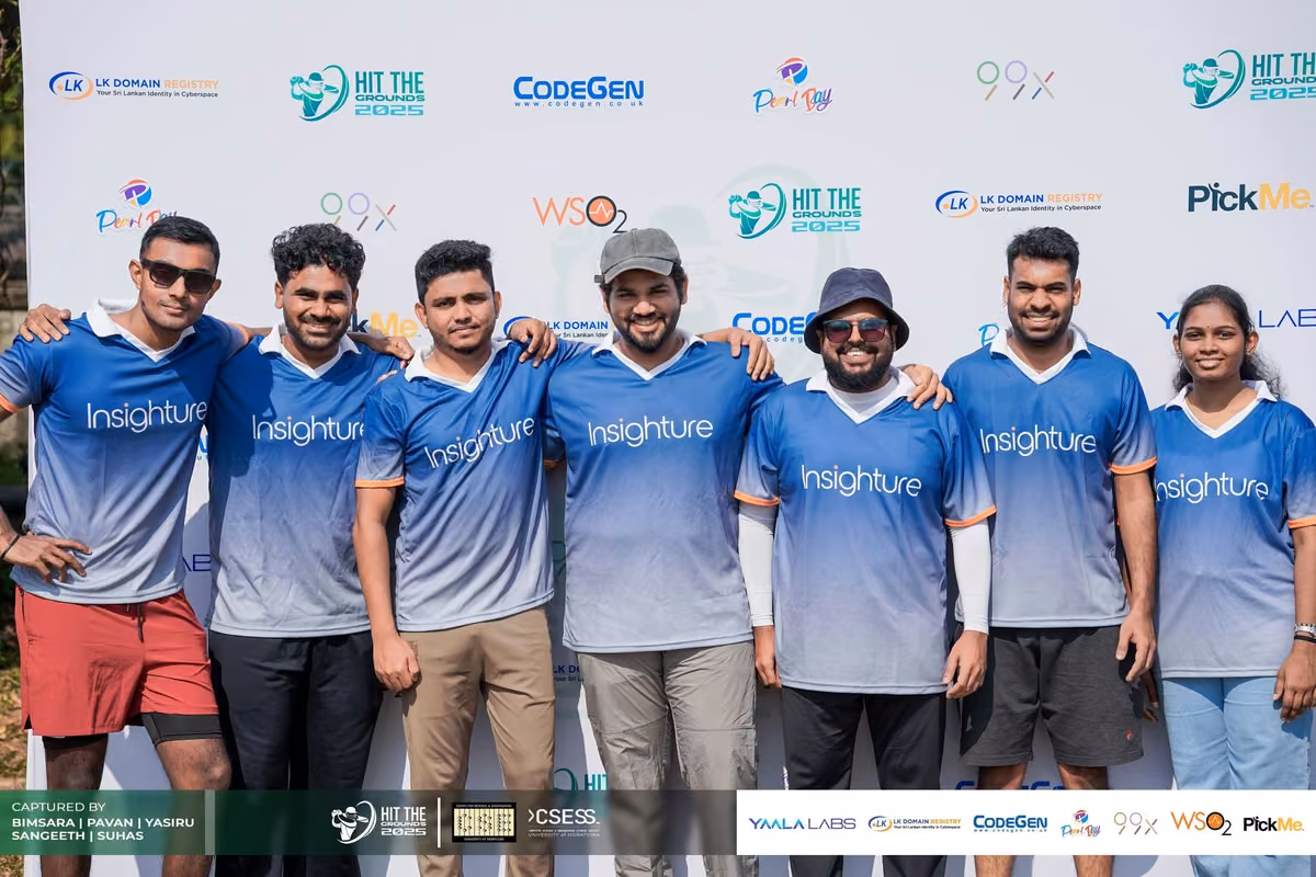 A team in blue jerseys with arms around each other in front of the backdrop
